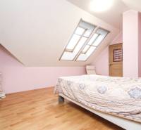 Világos hálószoba kétszárnyú tetőablakokkal és fa dekorációjú padlóval egy 4 szobás lakásban.