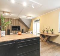 Egy 4 szobás lakás belső tere fa dekorációjú padlóval, fa elemekkel és növényekkel.