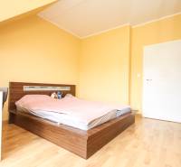 Hálószoba egy négy szobás lakásban, ággyal és fa dekorációjú padlóval.