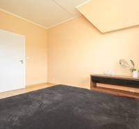 Hálószoba egy négy szobás lakásban fa mintázatú padlóval.