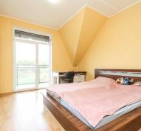 Hálószoba egy 4 szobás lakásban ággyal, szekrénnyel és fa dekorációjú padlóval.