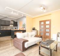 Nappali egy négyszobás lakásban, konyhával és fa dekorációjú padlóval.