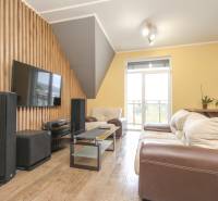 Nappali kanapéval, televízióval és fa dekorációjú padlóval egy 4 szobás lakásban.