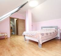 Tetőtéri hálószoba egy 4 szobás lakásban, fa dekor padlóval.