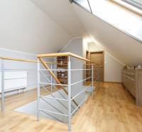 Négy szobás lakás tetőtéri folyosója fa dekorációs padlóval és tetőablakkal.