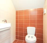 Fürdőszoba egy 4 szobás lakásban csempével és kompakt szaniter berendezéssel.