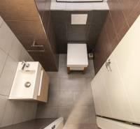 Fürdőszoba egy 4 szobás lakásban mosdóval, színes csempékkel és kompakt dizájnnal.