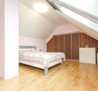 Hálószoba egy 4 szobás lakásban fa dekor padlóval és tetőablakkal.