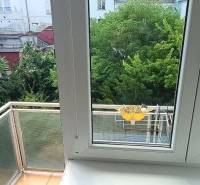 Kilátás egy 3 szobás lakásból, ablakokkal és erkéllyel a zöld udvarra.