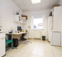 Iroda csempével, számítógéppel, bútorokkal és kávéfőzővel ellátott helyiség.