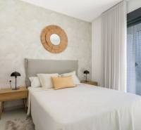 Hálószoba egy üdülő apartmanban, ágy, éjjeliszekrények, nagy ablak.