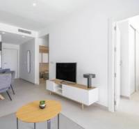 Nyaraló apartman nyitott nappalival, étkezőasztallal és fa dekorációjú padlóval.