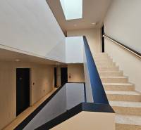 Lépcső terrazzo lépcsőkkel és világos mennyezettel egy háromszobás lakásban.