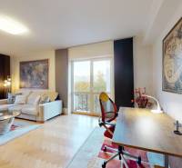 Nappali egy kétszobás lakásban kanapéval, íróasztallal és fa dekorációjú padlóval.