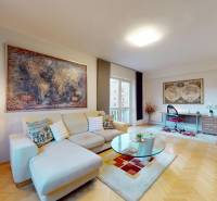 Nappali egy kétszobás lakásban fa dekor padlóval, kanapéval és íróasztallal.