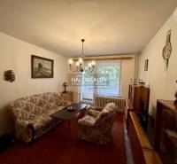 Nappali egy 4 szobás lakásban kényelmes bútorokkal, képpel, csillárral és kilátással.