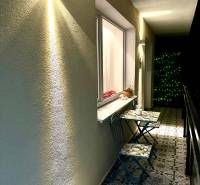 3 szobás lakás erkélye dekoratív csempékkel és fali világítással.