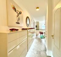 3 szobás lakás belső tere világos folyosóval, művészettel és bútorokkal.