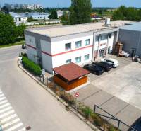 Kereskedelmi helyiségek a Trnava-i Strojárenská utcában, parkolóval és környező beépítéssel.