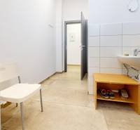 Kereskedelmi helyiség mosdóval, fehér fallal és fa dekorációjú padlóval.