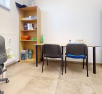 Irodai helyiségek polccal, székekkel és íróasztalokkal, fa dekorációjú padlóval.