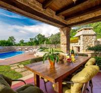 Egy villa külső része Bale városában medencével, asztallal és természeti részletekkel.