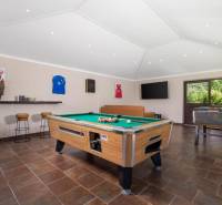 Villa belső tér biliárdasztallal, bőrkanapéval és fa dekorációjú padlóval.