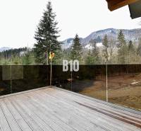 Házikó Terchovában terasszal, kilátással a havas hegyekre és erdőre.