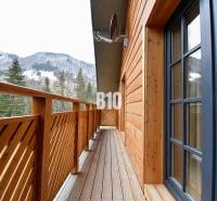 A terchovai ház erkélye kilátással a havas hegyekre és erdőkre.