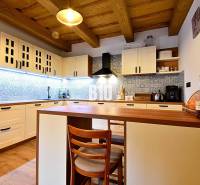 Konyha egy faháznál, fa mennyezettel, fa dekoros padlóval és kék csempékkel.