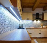 Konyha a házban csempézett falakkal és fa dekorációjú padlóval, LED világítással megvilágítva.