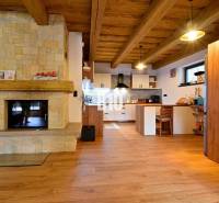 A kunyhó belső tere cserépkályhával, fa mennyezettel és fa dekorációjú padlóval.