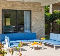A villa külső része Bale-ban kék kerti ülőgarnitúrával és kőfallal.