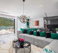 Tágas nappali a villában, kilátással a medencére és a természeti környezetre.