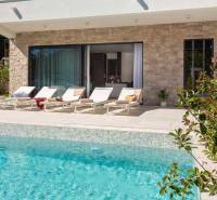 Egy villa külső része Baléban medencével és napozóágyakkal a teraszon.