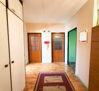 Folyosó szekrényekkel, világos falak, fa dekoros padló, 3 szobás lakás.