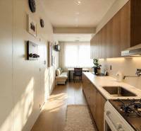 Hangulatos konyha egy 3 szobás lakásban, fa hatású padlóval és modern berendezéssel.