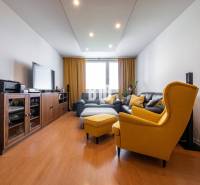 Nappali egy 4 szobás lakásban, fa mintázatú padlóval és sárga fotelekkel.