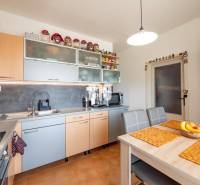 Konyha egy 4 szobás lakásban számítógéppel és fa dekorú konyhabútorral.