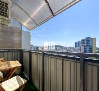 Egy 4 szobás lakás erkélye Nyitrán, kilátással a környező panelházakra.