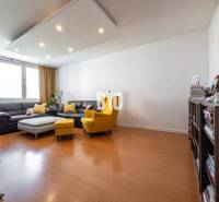 Nappali egy négy szobás lakásban, fa dekoros padlóval és kényelmes bútorokkal.