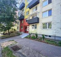 Nyitrán található egy lakóház érdekes színű homlokzattal, zöldterület közelében.