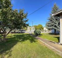 Kert egy családi háznál Ondrejovce-ben, gyep, fák és bokrok.