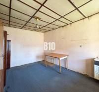 Egy családi ház szobájának belseje, amely tartalmaz szőnyeget, szekrényeket és egy asztalt.