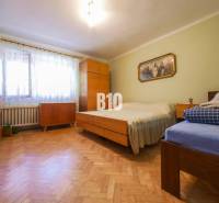 Hálószoba fa padlóval és egyszerű bútorokkal egy családi házban.