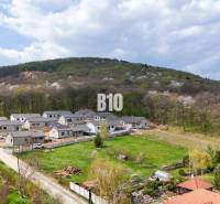 Lakóterületek Jelenecen, zölddel és erdőkkel körülvéve a lejtőkön.