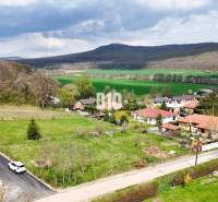 Telkek - lakóövezet Jelenecen, természet által körülvéve és családi házakkal, háttérben erdős dombokkal.