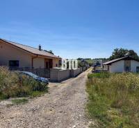 Családi házak az úttal körülvett füves területen Cséladicon, Lakóövezeti telkek.