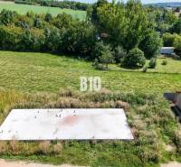 Lakóövezeti telek Cséladiban, zöld táj beton alappal és autóval.