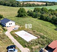 Telek kilátás lakóhely céljára Csallóközben, amely magában foglalja a házat, a zöldterületet és az autókat.